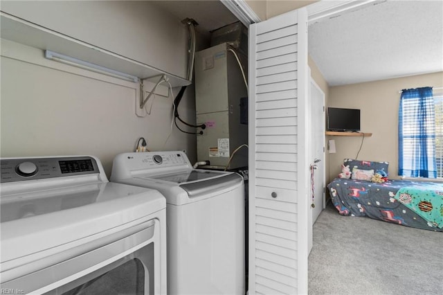 laundry area featuring light carpet, heating unit, and washing machine and clothes dryer