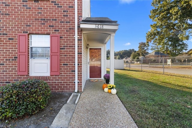 doorway to property with a lawn