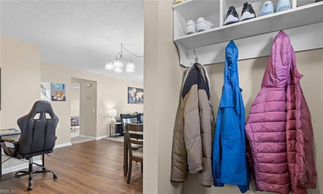 mudroom featuring an inviting chandelier, hardwood / wood-style floors, and a textured ceiling