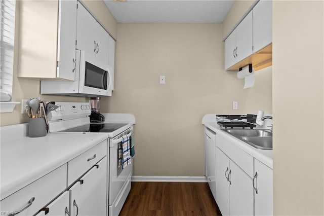 kitchen featuring white cabinetry, white appliances, dark hardwood / wood-style flooring, and sink