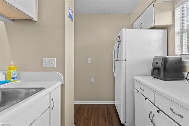 kitchen with white cabinetry, sink, dark hardwood / wood-style flooring, and white refrigerator