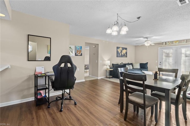 dining area with ceiling fan with notable chandelier, a textured ceiling, and dark hardwood / wood-style flooring