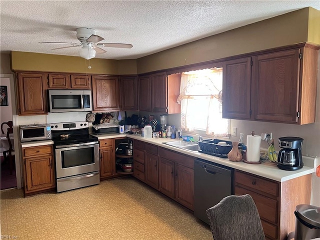 kitchen with sink, ceiling fan, a textured ceiling, and appliances with stainless steel finishes