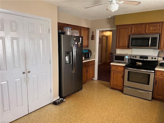 kitchen featuring ceiling fan, appliances with stainless steel finishes, and a textured ceiling