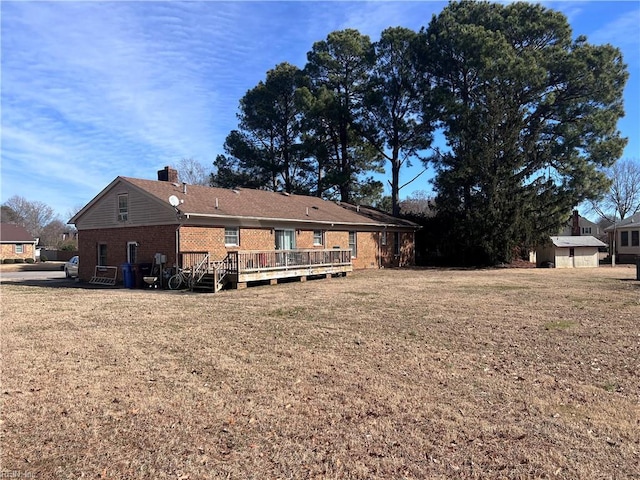 rear view of house with a yard and a deck