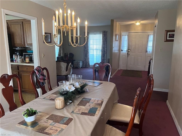 dining room featuring an inviting chandelier, dark carpet, and a textured ceiling