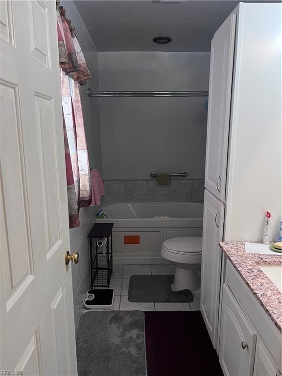 bathroom with a tub to relax in, tile patterned floors, toilet, and vanity