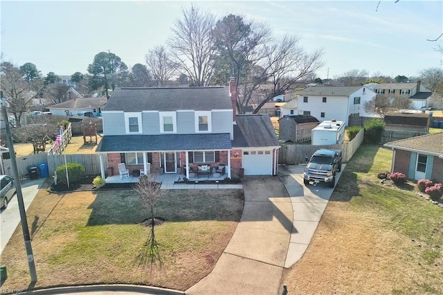 view of front of property featuring a porch, a garage, and a front lawn