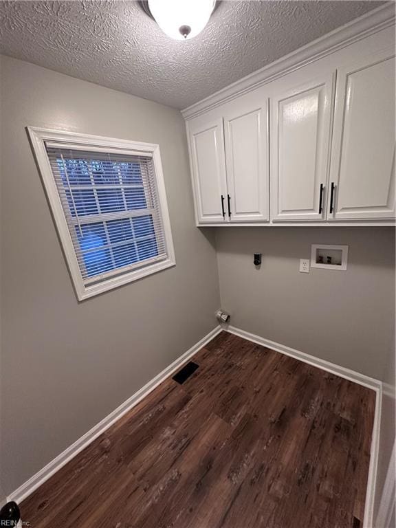 laundry area with dark wood-type flooring, cabinets, a textured ceiling, hookup for a washing machine, and hookup for an electric dryer