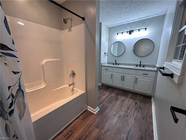 bathroom with vanity, wood-type flooring, shower / bath combo, and a textured ceiling