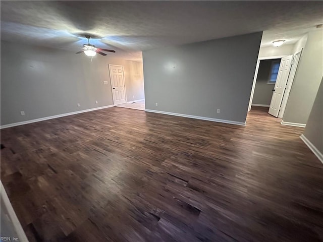 empty room featuring dark wood-type flooring and ceiling fan