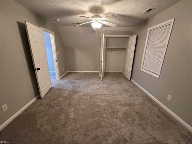 unfurnished bedroom with ceiling fan, lofted ceiling, light carpet, and a textured ceiling