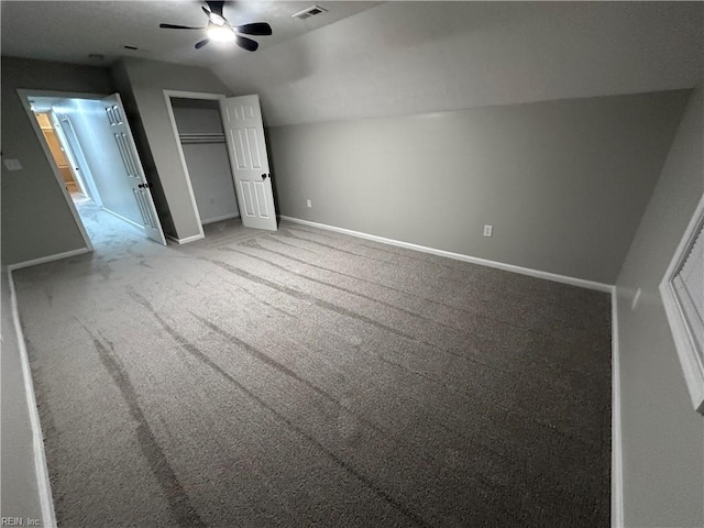 unfurnished bedroom featuring lofted ceiling, carpet floors, ceiling fan, and a closet