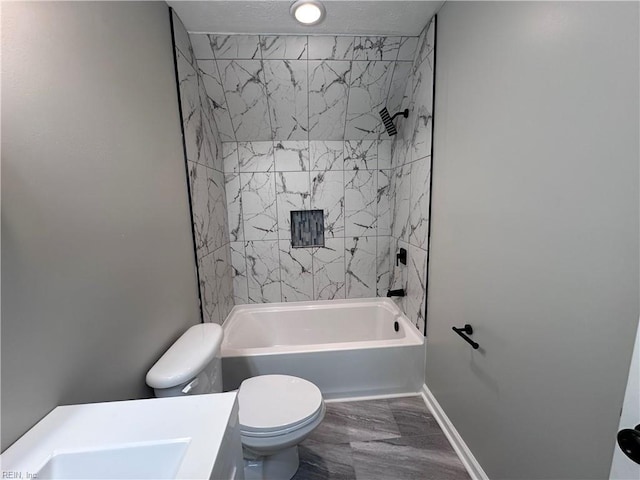 bathroom featuring tiled shower / bath and toilet