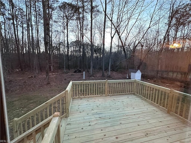 deck at dusk featuring a storage unit