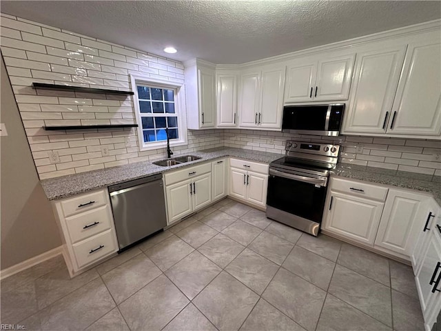 kitchen with white cabinetry, appliances with stainless steel finishes, sink, and light tile patterned flooring