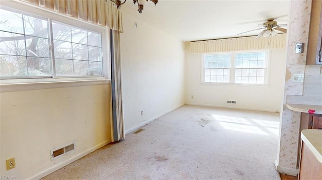 spare room with light colored carpet and ceiling fan