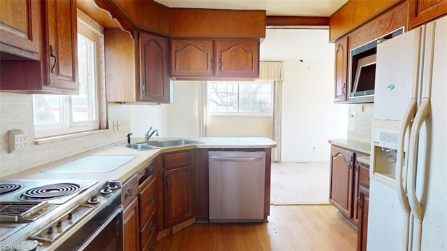 kitchen featuring a healthy amount of sunlight, dishwasher, sink, and white fridge with ice dispenser