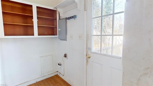 clothes washing area with hardwood / wood-style flooring and electric panel