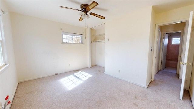 unfurnished bedroom with light carpet, a closet, and ceiling fan