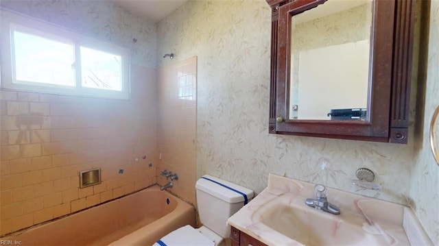 full bathroom with vanity, tiled shower / bath combo, and toilet