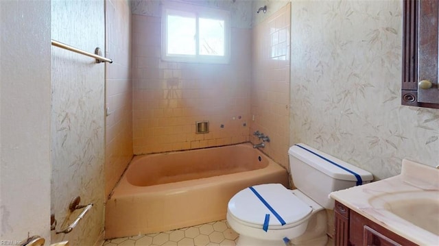 full bathroom with tiled shower / bath combo, vanity, and toilet