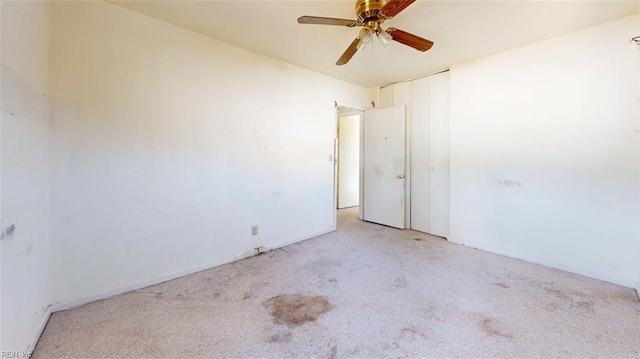 carpeted spare room featuring ceiling fan