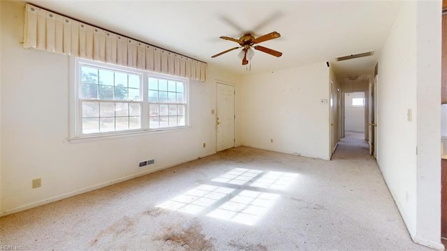 carpeted spare room featuring ceiling fan