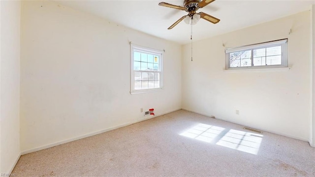 carpeted empty room with plenty of natural light and ceiling fan