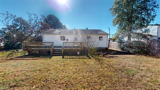 back of house featuring a wooden deck and a lawn