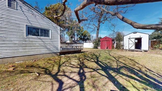 view of yard featuring a wooden deck and a shed