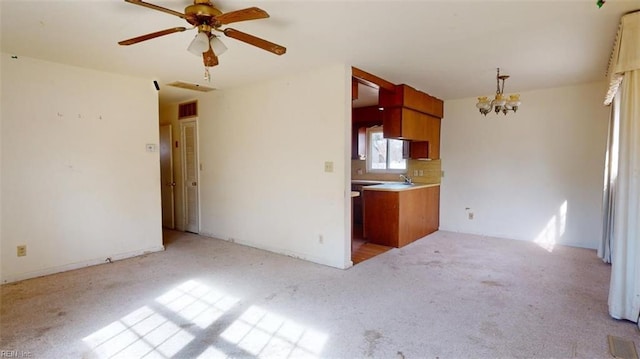 kitchen featuring ceiling fan with notable chandelier and light colored carpet