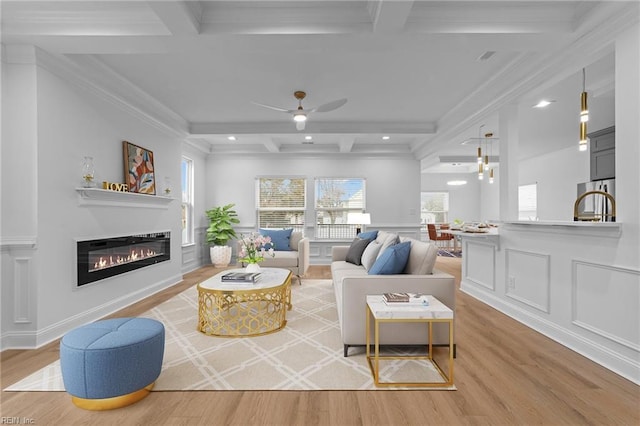 living room featuring beamed ceiling, coffered ceiling, and light hardwood / wood-style flooring