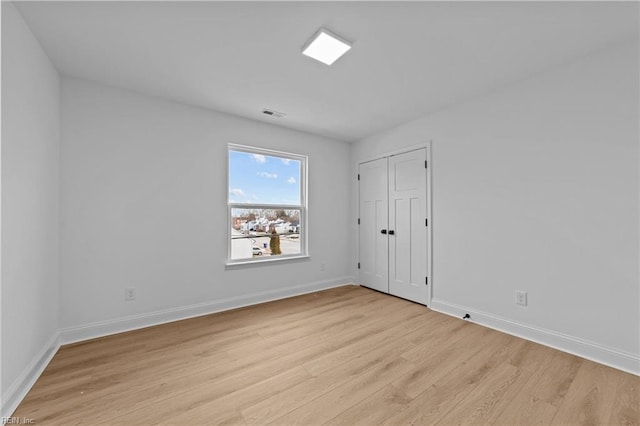 empty room with light hardwood / wood-style flooring