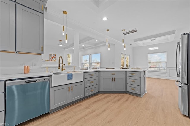 kitchen featuring pendant lighting, sink, appliances with stainless steel finishes, gray cabinetry, and light wood-type flooring