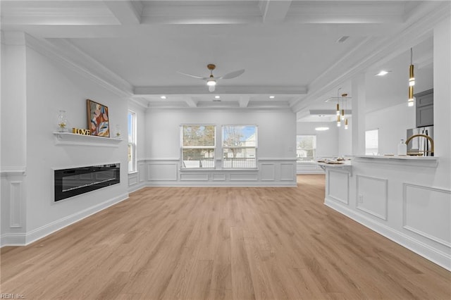 unfurnished living room with beamed ceiling, ceiling fan, coffered ceiling, and light hardwood / wood-style floors