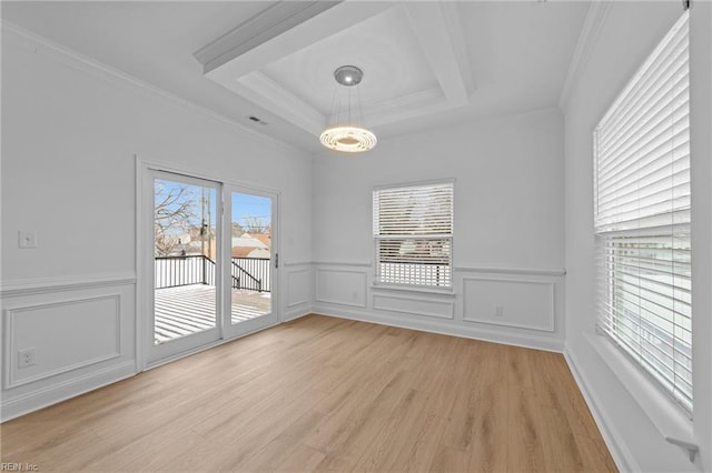 spare room with crown molding, a tray ceiling, and light hardwood / wood-style flooring