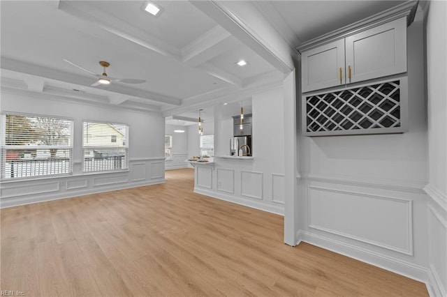 unfurnished living room with ceiling fan, coffered ceiling, beam ceiling, and light hardwood / wood-style flooring