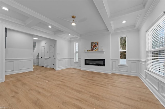 unfurnished living room featuring light hardwood / wood-style flooring, beam ceiling, a wealth of natural light, and ceiling fan