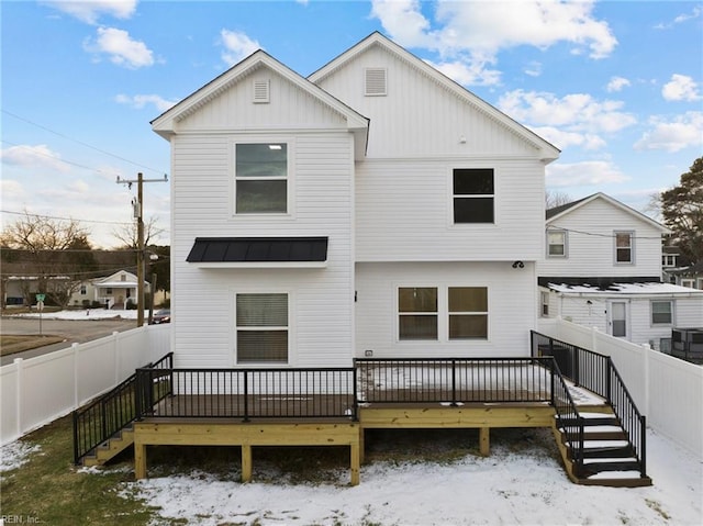 snow covered house with a deck