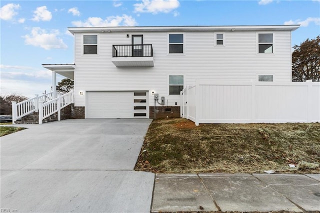 rear view of property with a garage and a balcony