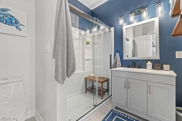 bathroom with vanity, toilet, and a shower with door