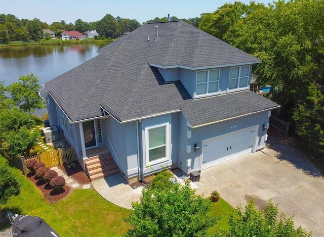 view of front of home featuring a garage, a water view, and a front lawn