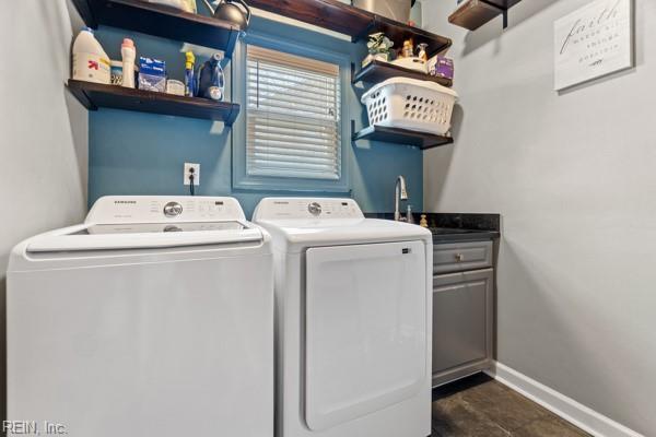 washroom with cabinets, separate washer and dryer, and sink