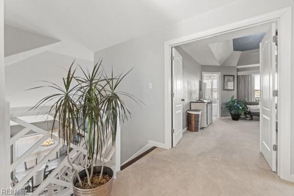 hallway with light carpet and lofted ceiling