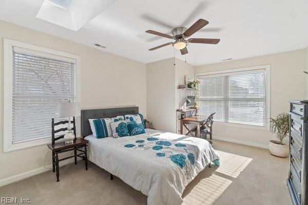 bedroom featuring light carpet, ceiling fan, and a skylight