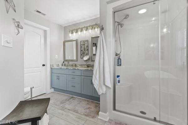 bathroom with vanity and a shower with door