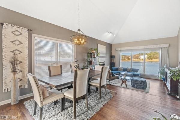 dining area with an inviting chandelier, plenty of natural light, high vaulted ceiling, and wood-type flooring