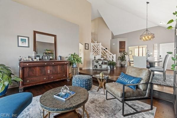 living area featuring wood-type flooring, lofted ceiling, and a notable chandelier