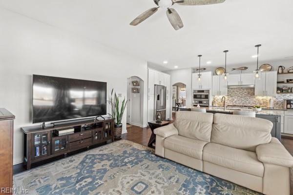 living room featuring sink, wood-type flooring, and ceiling fan